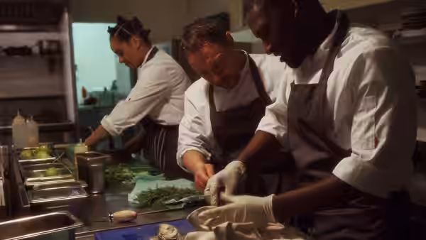 Chefs including Andy Jones (Stephen Graham) preparing food at a kitchen counter