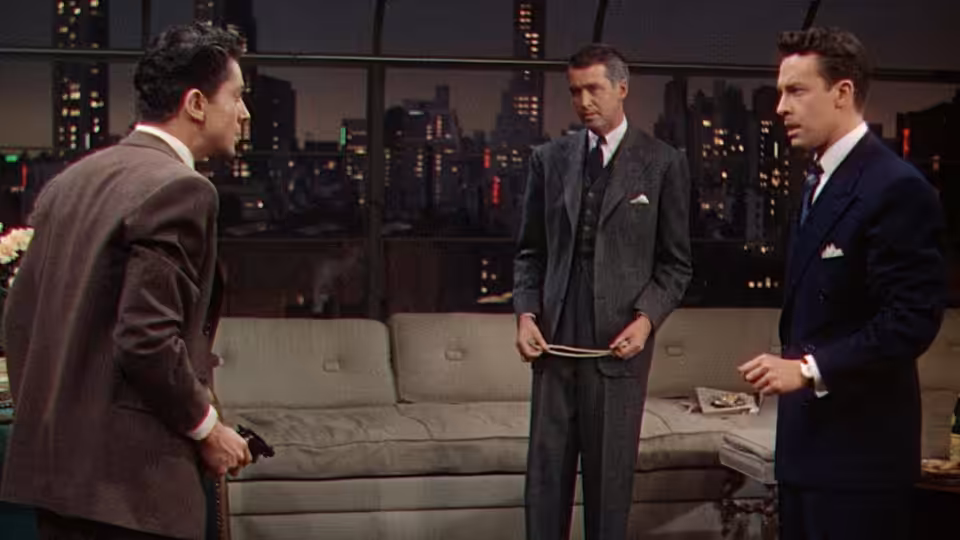 Brandon Shaw (John Dall), Phillip Morgan (Farley Granger), and Rupert Cadell (James Stewart) gather in the apartment living room