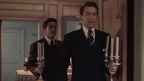 Brandon Shaw (John Dall) carries a candelabrum beside Phillip Morgan (Farley Granger) in the apartment