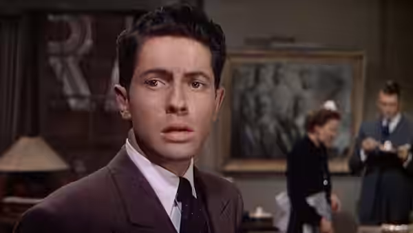 Kenneth Lawrence (Douglas Dick) turns toward the others in the apartment living room