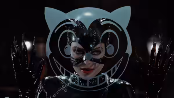Catwoman (Michelle Pfeiffer) wearing a large cat mask and raising her hands
