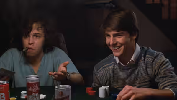 Joel Goodson (Tom Cruise) smiles at a card table with Miles Dalby (Curtis Armstrong)