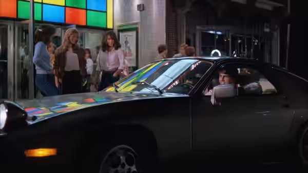 Joel Goodson (Tom Cruise) sits in the driver's seat of a Porsche at night