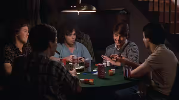 Joel Goodson (Tom Cruise) plays cards with friends around a green table