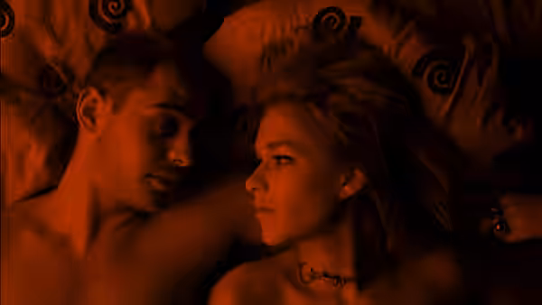 A man and a woman lying in bed facing each other