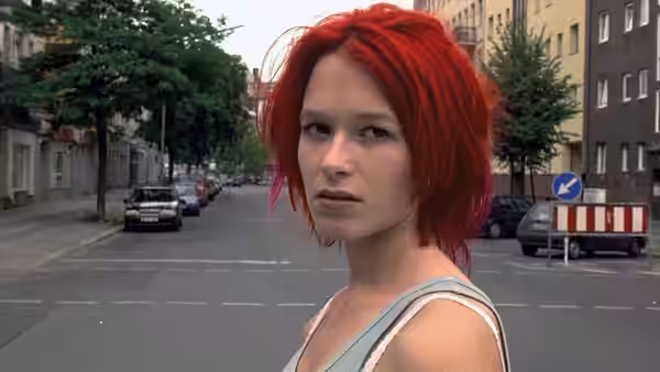 Lola (Franka Potente) standing on an empty city street looking ahead
