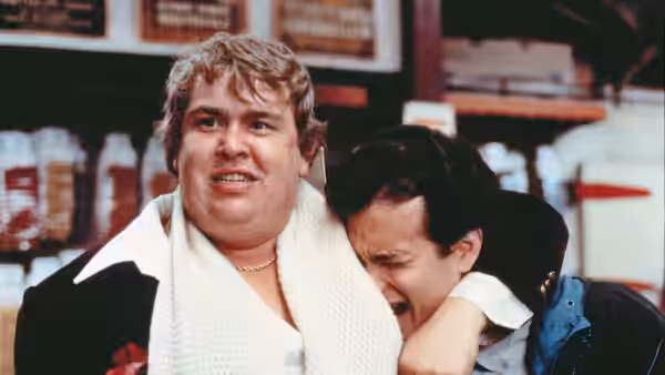 Freddie Bauer (John Candy) holds Allen Bauer (Tom Hanks), who leans against him