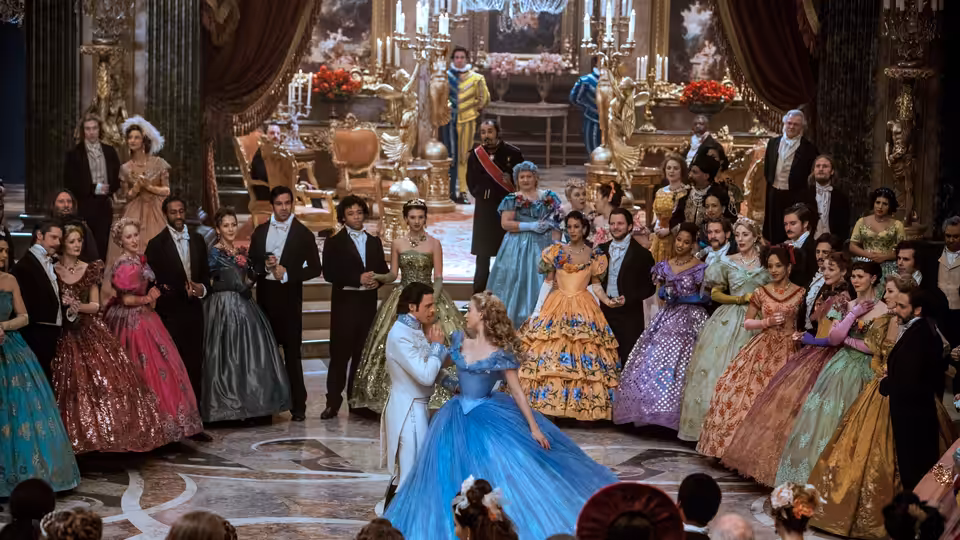 Cinderella (Lily James) dances with the Prince at a crowded royal ball