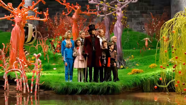 Willy Wonka (Johnny Depp) stands with children among colorful trees by a river