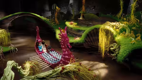 Willy Wonka (Johnny Depp) and children ride a pink boat along a chocolate river