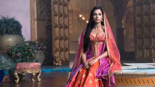 Jasmine (Naomi Scott) standing in an ornate palace interior