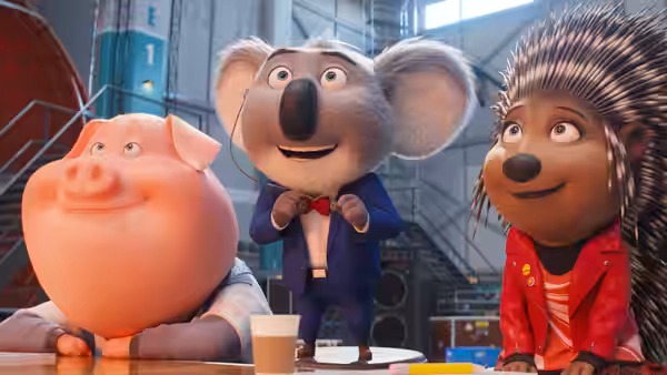 Pig koala and hedgehog seated together at a table indoors