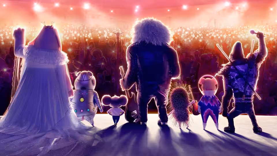 Group of animals standing on stage facing a large audience