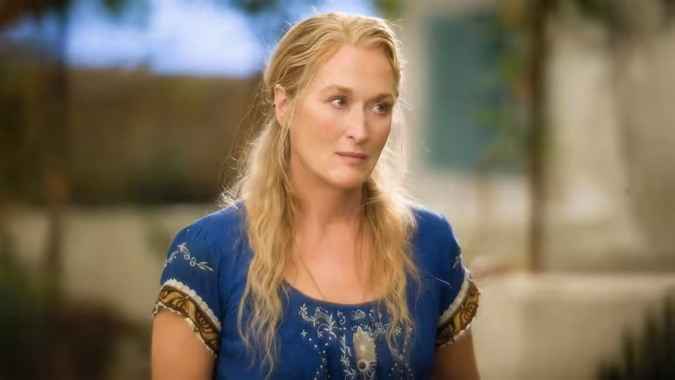 Donna Sheridan (Meryl Streep) stands outside looking to her left