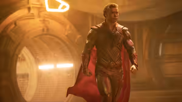 Adam Warlock (Will Poulter) striding through a grand golden chamber in ornate armor