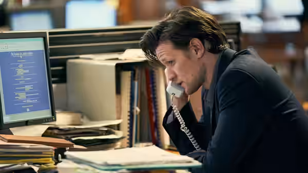 Martin Bright (Matt Smith) speaking on the phone at his desk