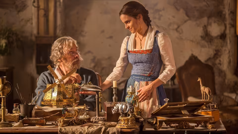 Maurice (Kevin Kline) and Belle (Emma Watson) examining mechanical devices on a workbench