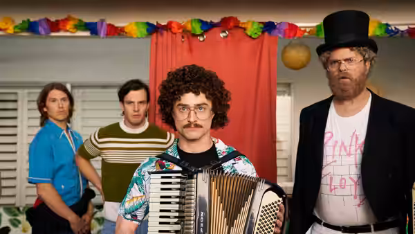 Weird Al (Daniel Radcliffe) holds an accordion flanked by three men including one in a top hat