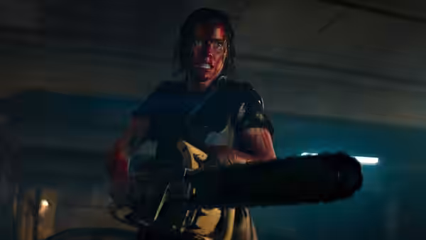 Beth (Lily Sullivan) wielding a chainsaw while covered in blood in a parking garage