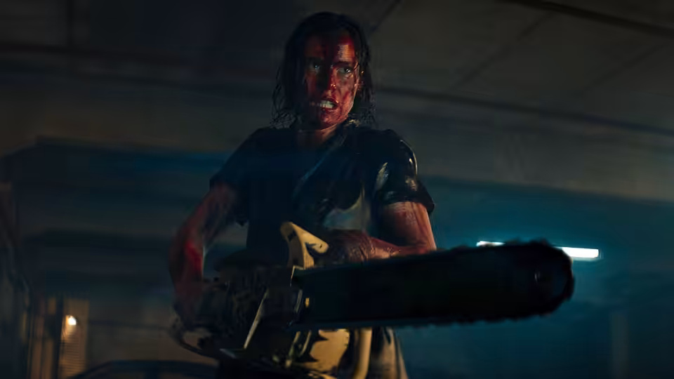 Beth (Lily Sullivan) wielding a chainsaw while covered in blood in a parking garage