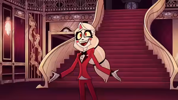 Charlie Morningstar gesturing with arms open before a grand staircase