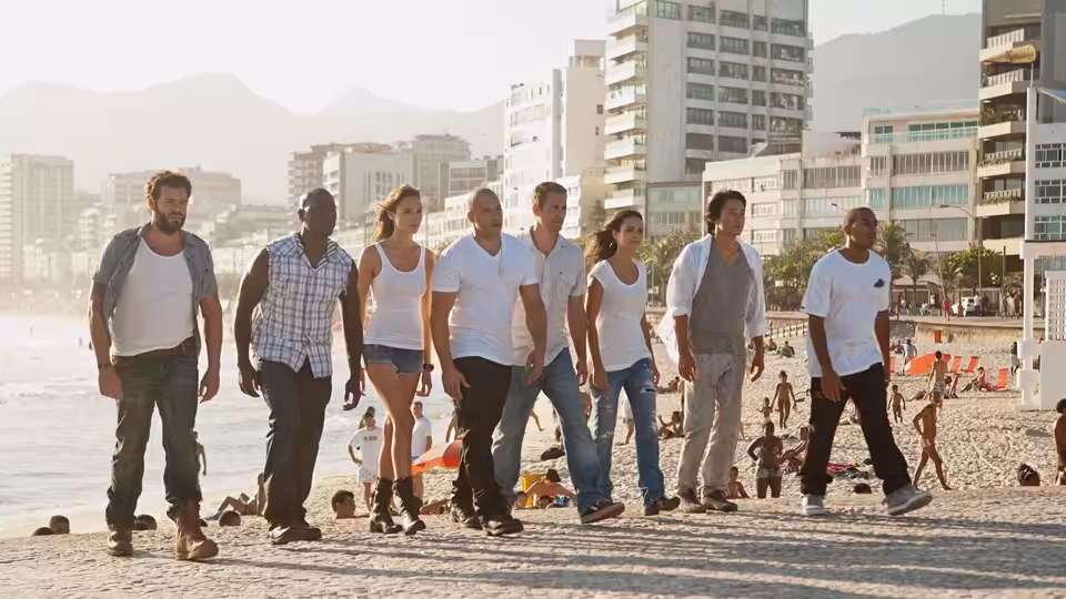 Dominic Toretto (Vin Diesel), Brian O'Conner (Paul Walker), and their crew walk along a Brazilian beach