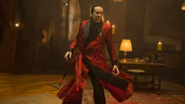 Dracula (Nicolas Cage) poses in a red robe inside an ornate room