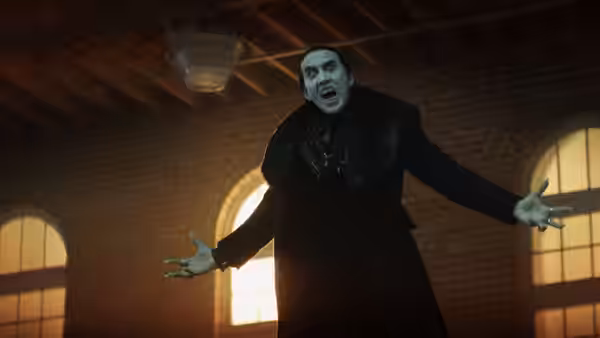Dracula (Nicolas Cage) stands with arms outstretched in a brick hall