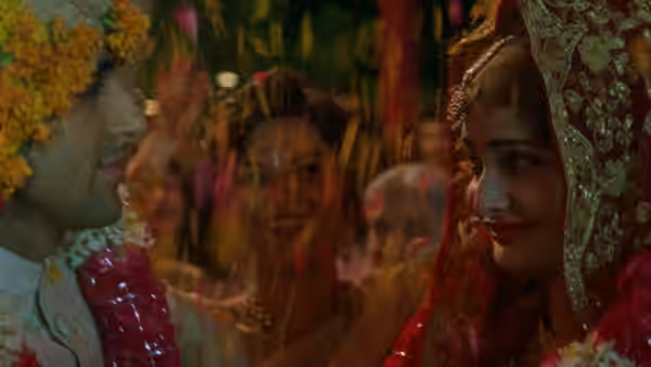 A bride in a red veil faces the groom during their wedding ceremony