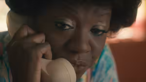 Deloris Jordan (Viola Davis) speaking closely on telephone receiver