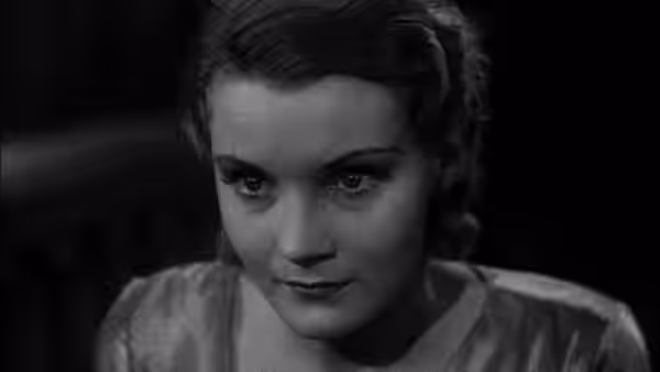 A woman looks downward in a close-up