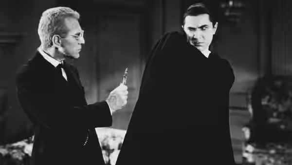 Van Helsing (Edward Van Sloan) holds up a crucifix as Count Dracula (Bela Lugosi) faces him