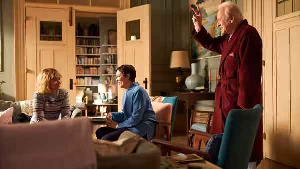 Anthony (Anthony Hopkins) stands gesturing in a living room as a woman and man watch