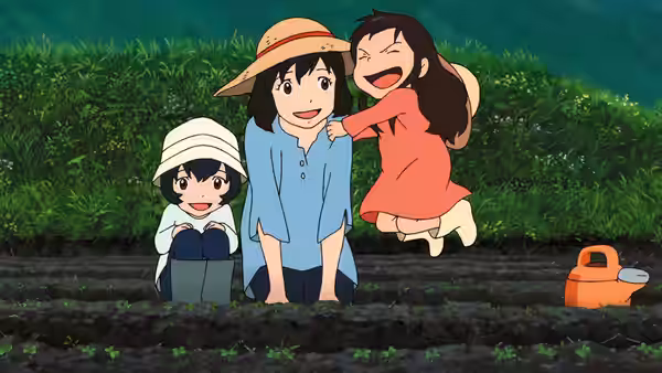 Three girls laughing and playing together in a vegetable garden