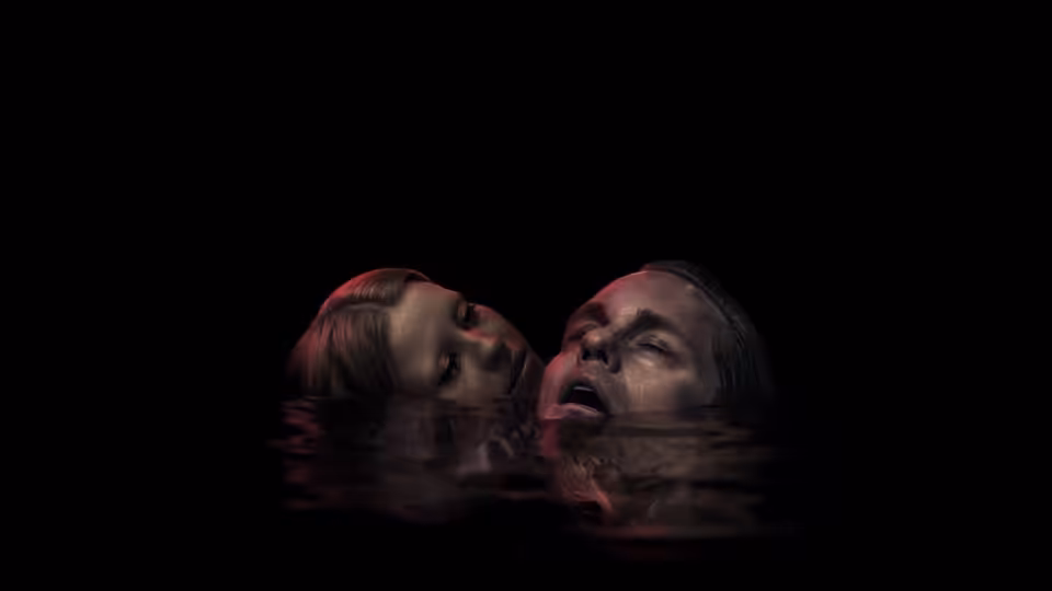 Two women float neck-deep in dark water with heads tilted back