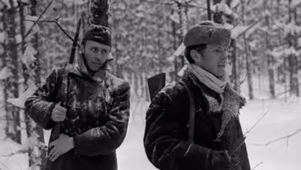 Sotnikov (Boris Plotnikov) and Rybak (Vladimir Gostyukhin) move through a snowy forest