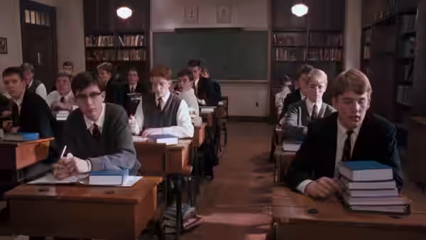 Students seated at wooden desks inside a sunlit classroom