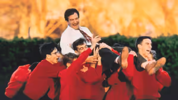 John Keating (Robin Williams) carried aloft by boys in red sweaters