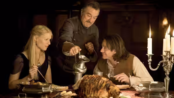 Yvaine and Tristan dine at a candlelit table as Captain Shakespeare pours them a drink