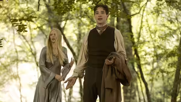 Tristan and Yvaine walk hand in hand through a sunlit forest