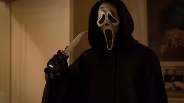 Ghostface raising a knife in a dimly lit room
