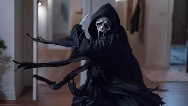 Ghostface wielding a knife in a residential hallway