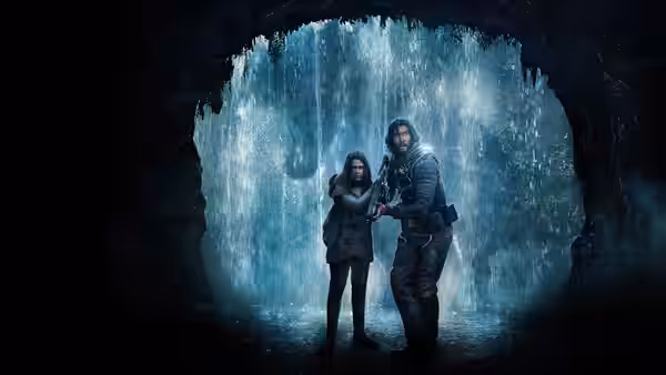 Mills (Adam Driver) and Koa (Ariana Greenblatt) stand together in a cave with falling water