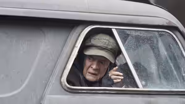 Miss Shepherd (Maggie Smith) peers through the small side window of her van
