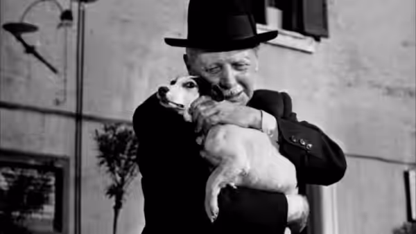 Umberto Domenico Ferrari (Carlo Battisti) embracing Flike the dog in the street