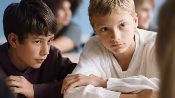 Léo (Eden Dambrine) and Rémi (Gustav De Waele) seated together in a classroom