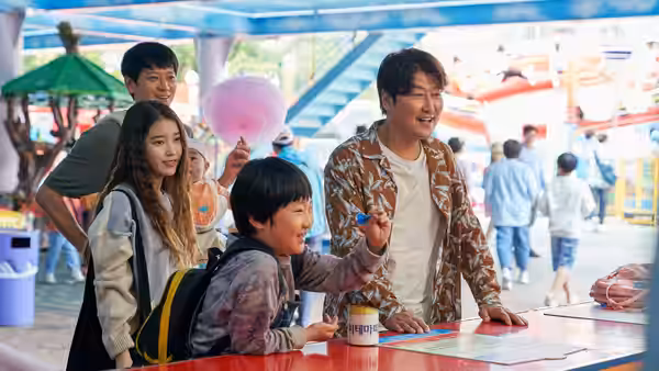 Sang-hyun (Song Kang-ho) with So-young (IU) and Hae-jin at a fair counter