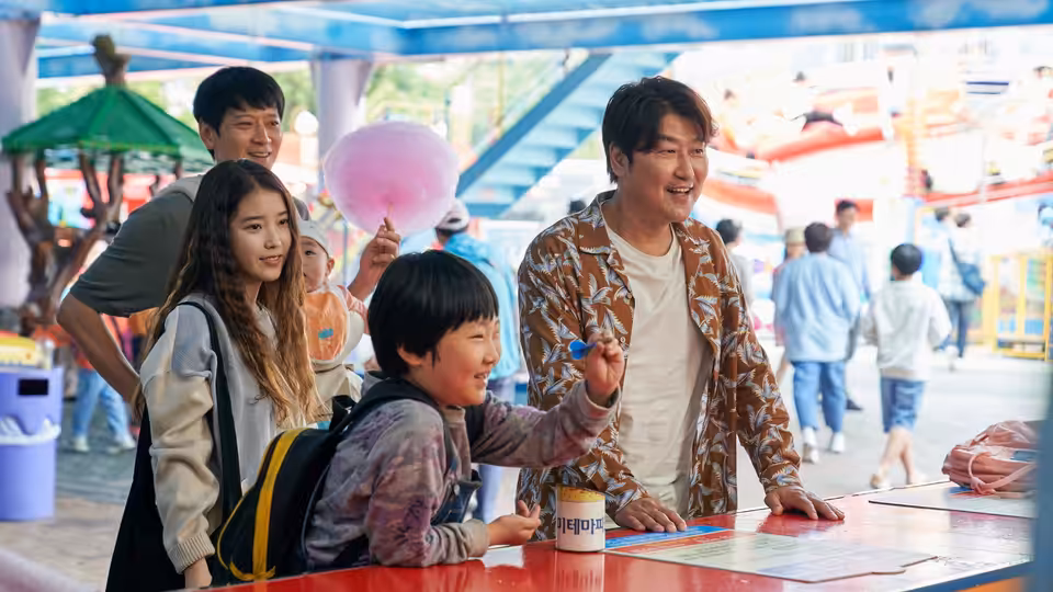 Sang-hyun (Song Kang-ho) with So-young (IU) and Hae-jin at a fair counter
