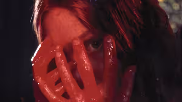 Carrie (Sissy Spacek) with blood covering her face and raised hand