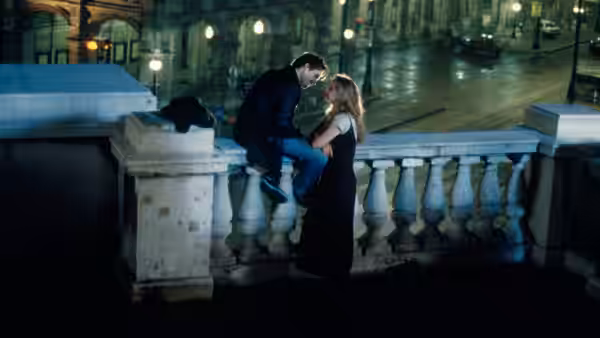 Jesse (Ethan Hawke) and Céline (Julie Delpy) sitting together on a stone bridge at night